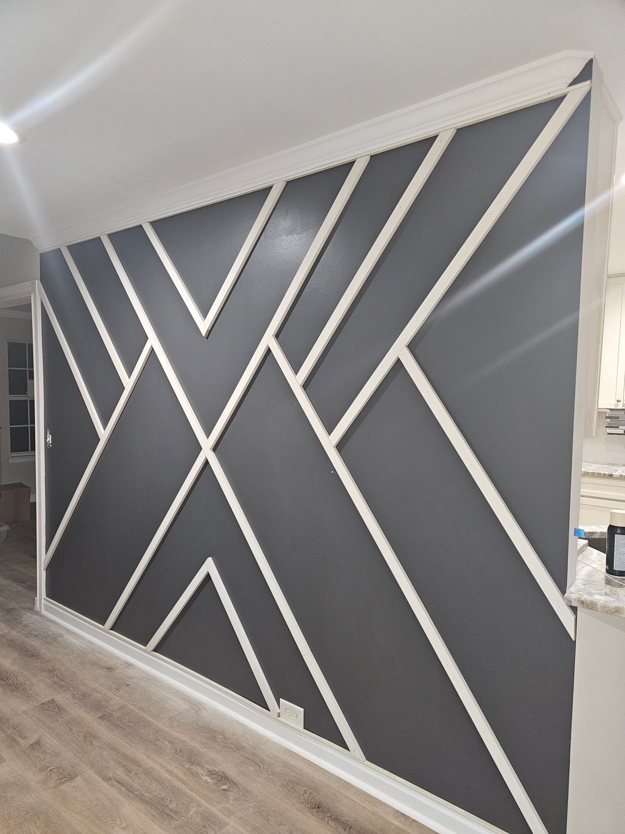 The same hallway wall finished, with white battens forming a geometric pattern.